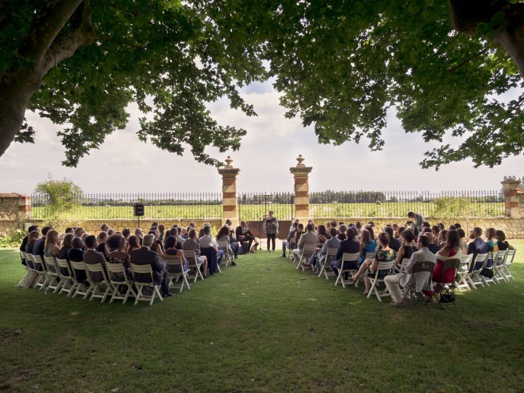Outdoor wedding ceremony under large oak trees in France